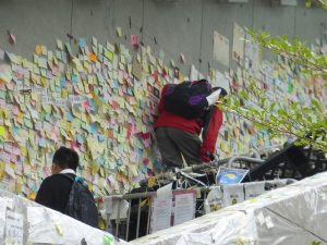 People clamber over the barricades to add to the sticky-note messages